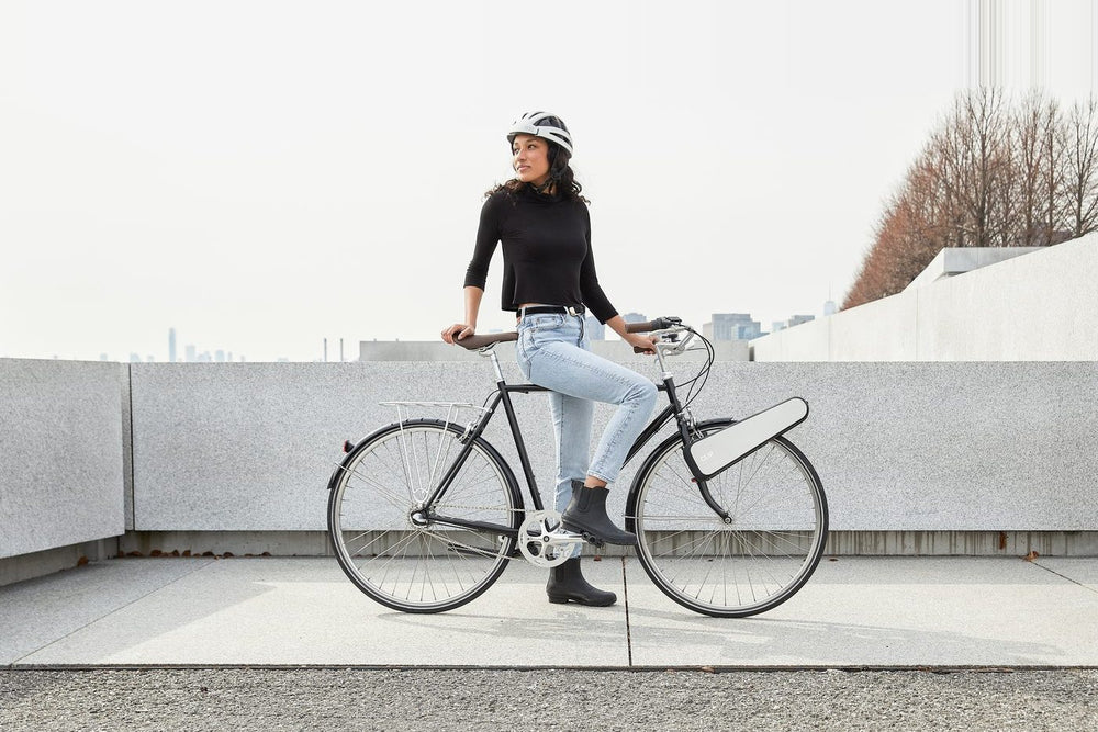 A rider stopped with CLIP clipped to the front wheel of her bike