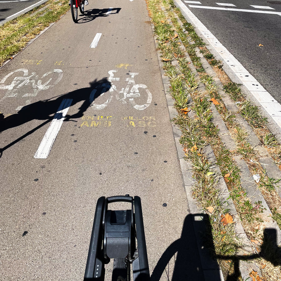 A rider’s view down a painted bike lane, CLIP on the front wheel