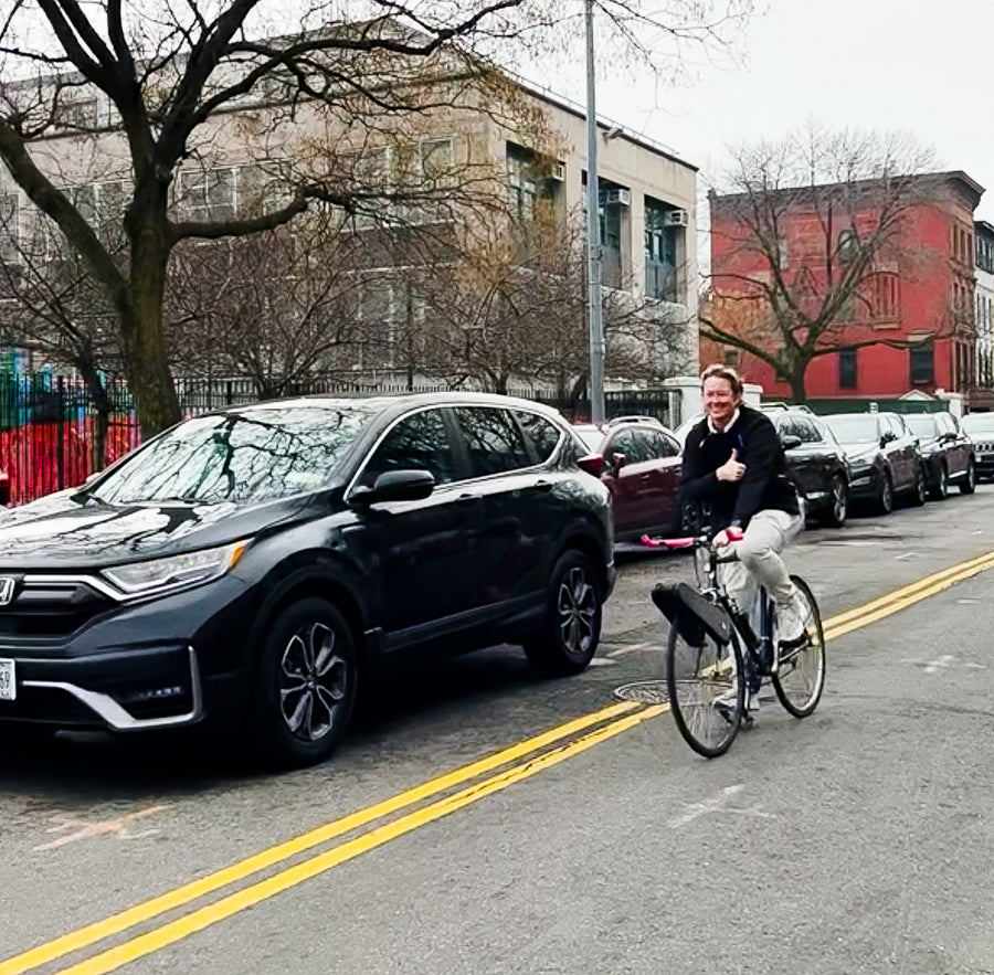 A rider on a CLIP bike crossing a city street between cars